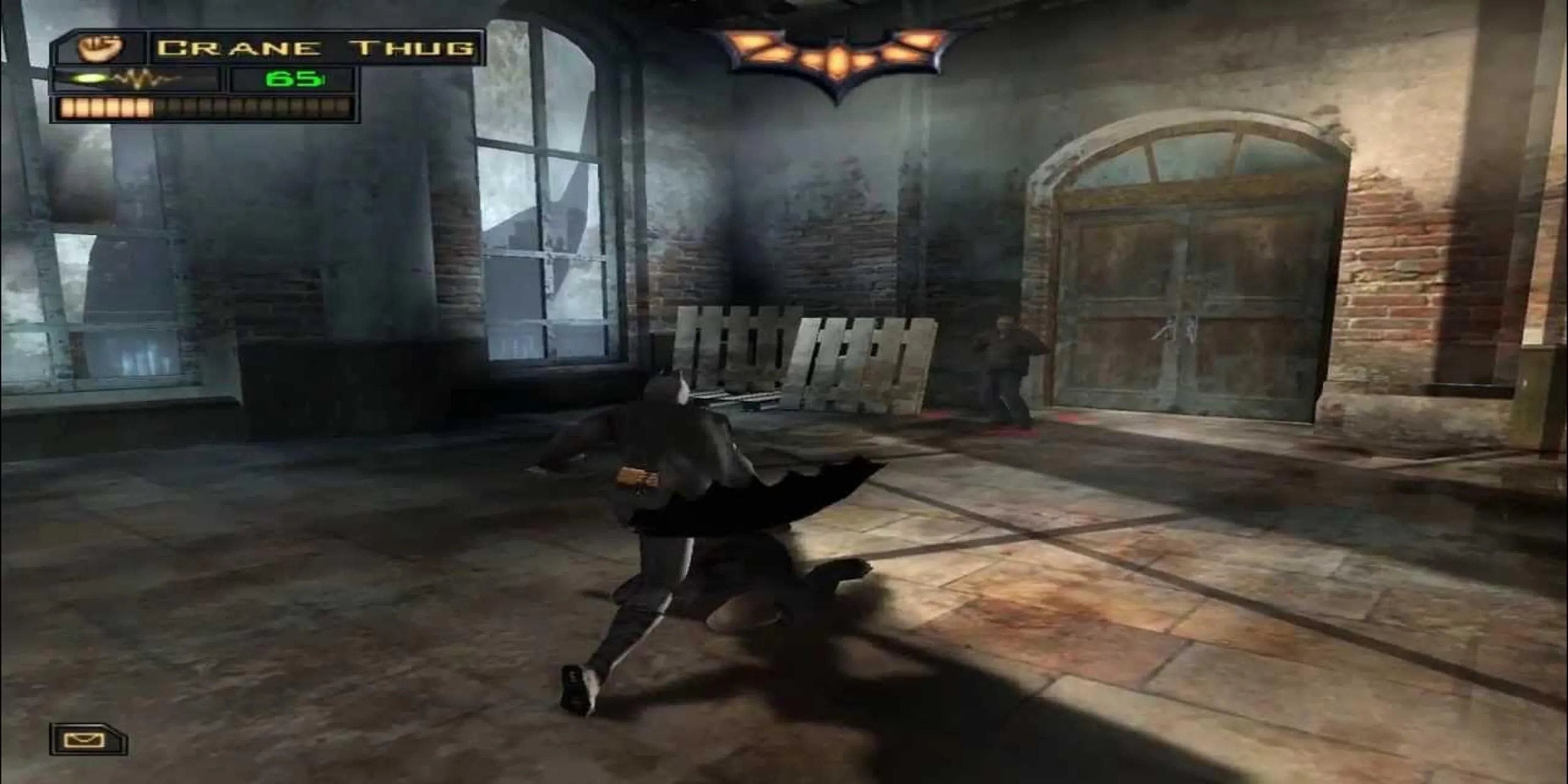 Batman đối mặt với một tên côn đồ trong cảnh tối của Batman Begins