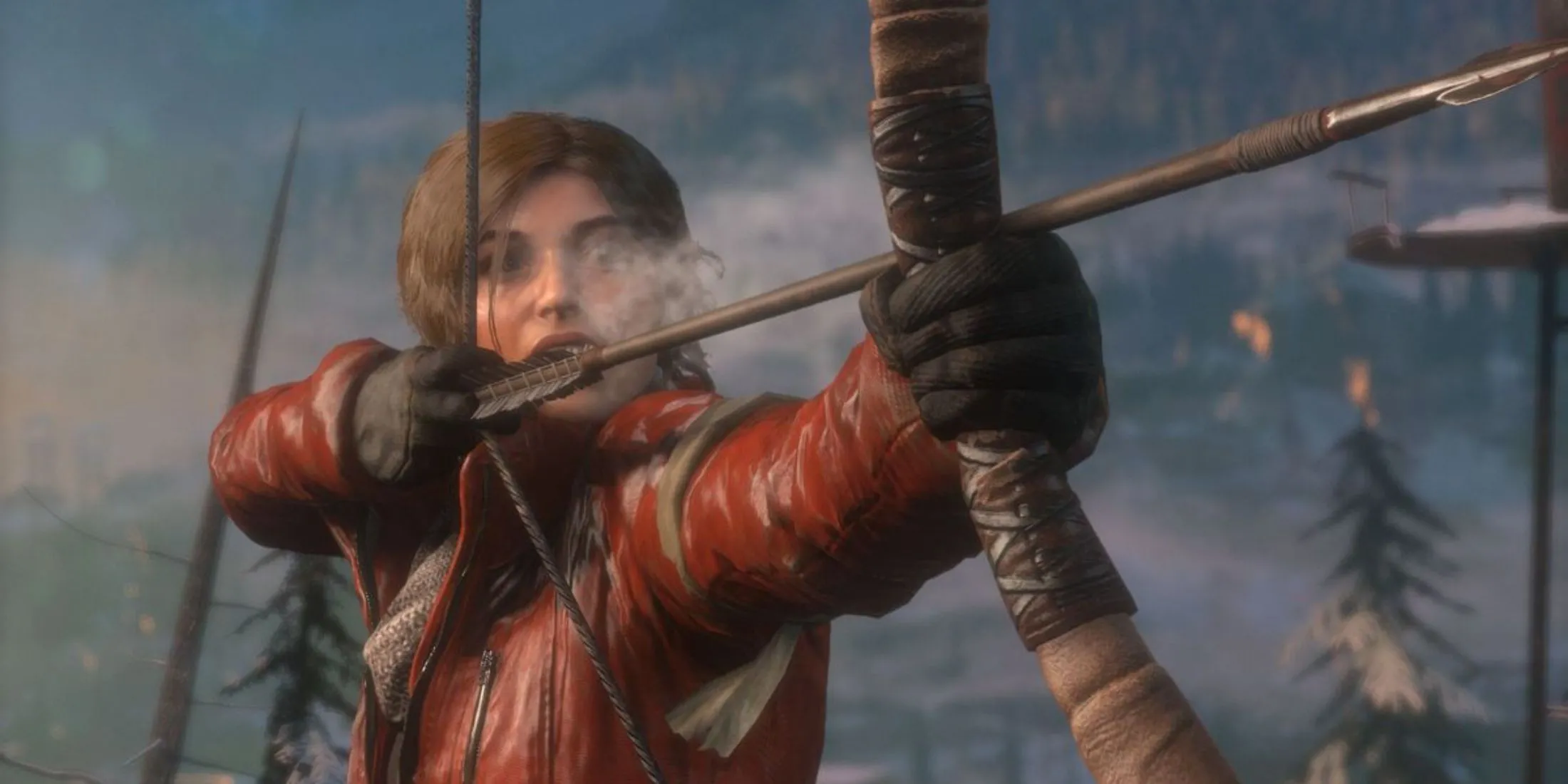 Lara Croft đang nhắm cung tên giữa khu rừng phủ tuyết trong game Rise Of The Tomb Raider
