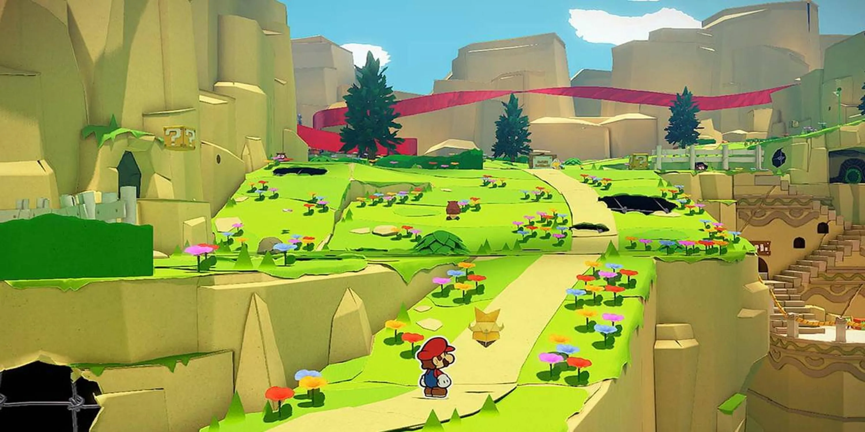 Mario giấy đứng trên con đường dẫn lên ngọn đồi với khung cảnh rực rỡ trong Paper Mario: The Origami King